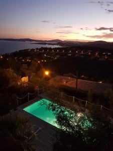 Saint-Peïre-sur-Mer的住宿－Villa Marcelline Belle vue mer Golfe de Saint Tropez，日落时在房子后院的游泳池