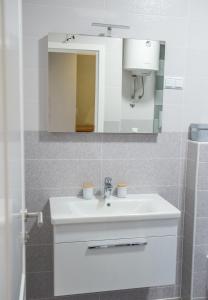 a bathroom with a white sink and a mirror at Apartment Light De Luxe - with Old Bridge view in Mostar +40 photos
