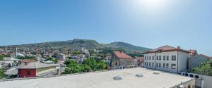 a view of a city with a mountain in the background at Apartment Light De Luxe - with Old Bridge view in Mostar