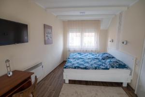 Dormitorio pequeño con cama y TV en Art Magánszálláshely, en Debrecen