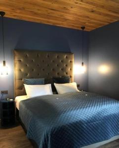 a blue bedroom with a large bed with two lamps at Hótel Kría in Vík