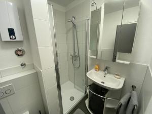 uma casa de banho branca com um chuveiro e um lavatório. em Ferienwohnung Frieda mit überdachtem Balkon em Winterberg