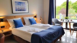 ヤストシェンビャ・グラにあるWilla Abrazjaのベッドルーム1室(青い枕のベッド1台、窓付)