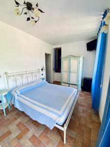 a bedroom with a bed with blue sheets and blue curtains at Sandra Villa Rooms in Corniglia