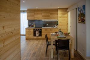 a kitchen with wooden walls and a table and chairs at Casa Galèt in Tirano