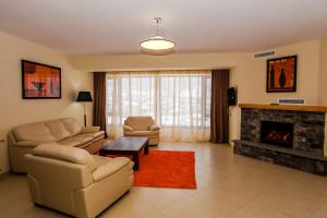 - un salon avec un canapé, des chaises et une cheminée dans l'établissement Crystal Hill Resort, à Bakuriani