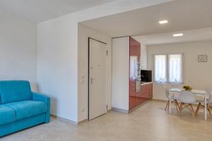 een woonkamer met een blauwe bank en een tafel bij La Sensa Apartments in Brenzone sul Garda