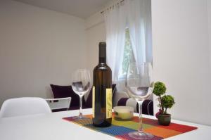 a bottle of wine sitting on a table with two glasses at Apartments Nina Tivat in Tivat