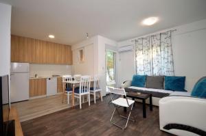 ein Wohnzimmer und eine Küche mit einem Sofa und einem Tisch in der Unterkunft Apartments Nina Tivat in Tivat
