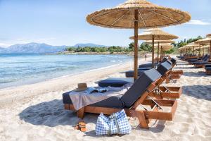 a group of chairs and umbrellas on a beach at The Marble Resort in Drosia