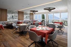 a restaurant with tables and chairs and windows at Appartement-Hotel Beatenhof in Tirolo