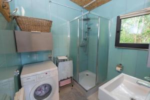 y baño con lavadora y ducha. en Bogacki Domek, en Giżycko