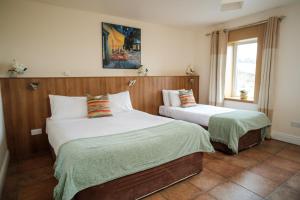 a bedroom with two beds and a window at The Lodge Doolin in Doolin