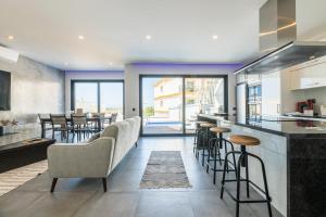 a kitchen and living room with a bar with stools at Villa Miragem Alvor in Alvor