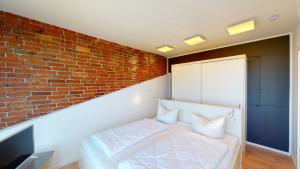 a bedroom with a brick wall and a bed at Speicher Residenz Barth E5 App 6 in Barth