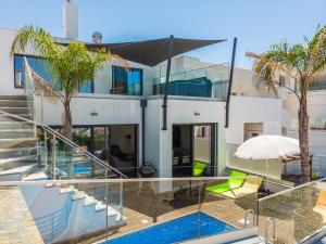 a house with a swimming pool and glass walls at Villa Miragem Alvor in Alvor
