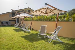 un groupe de chaises et de parasols dans une cour dans l'établissement La Colombiera Relais, à Castelnuovo Magra