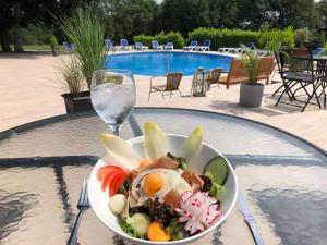 a bowl of salad on a table next to a glass of water at Globales Post Hotel & Wellness in Herstal