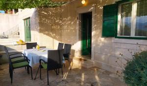 a table and chairs sitting on a patio at Garden apartment with a View in Postira +31 photos