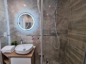a bathroom with a sink and a shower at Apartamenty Na Fali w Gąskach - 365PAM in Gąski