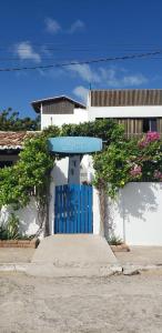 une porte bleue devant un bâtiment blanc dans l'établissement CASA PIPA BG, à Barra Grande
