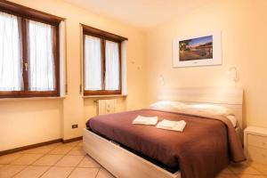 a bedroom with a bed with two towels on it at Verona Fiera Suite in Verona