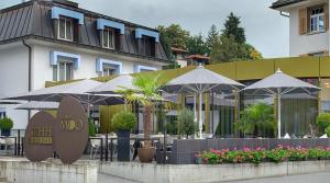a restaurant with tables and umbrellas in front of a building at Herisau Apartments in Herisau