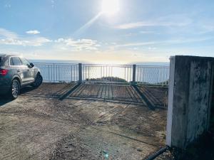 une voiture garée au-dessus d'un balcon donnant sur l'océan dans l'établissement PARADIS AU SOLEIL, vue panoramique sur mer, à Bouillante