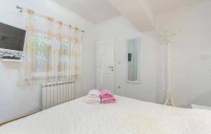 een paar roze handdoeken bovenop een bed bij Apartmani Cupar in Poreč