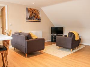 a living room with two chairs and a television at Springfield House in Stafford