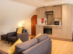 a living room with a couch and a kitchen at Springfield House in Stafford