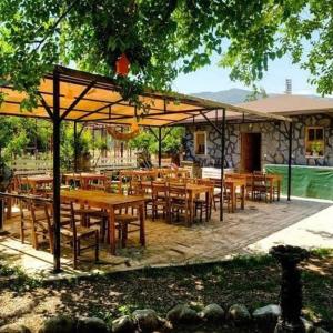 um restaurante com mesas e cadeiras de madeira sob um dossel em Gaia Hotel Olimpos em Kumluca