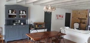 Una cocina y un comedor con mesa y sillas. en Les Ruettes, en Saint-Germain-sur-Sarthe