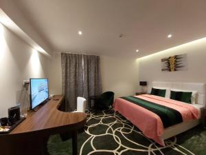 
a bedroom with a bed and a desk at Basrah International Airport Hotel in Al Başrah
