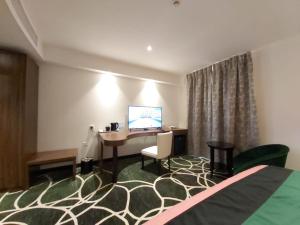 a hotel room with a desk and a bed at Basrah International Airport Hotel in Al Başrah