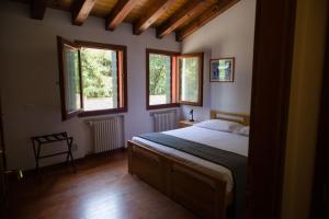 um quarto com uma cama e duas janelas em Cornarorooms em Castelfranco Veneto