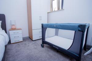 ein Schlafzimmer mit einem Bett mit einem blauen Etagenbett in der Unterkunft Spacious Urban City Apartment in Doncaster