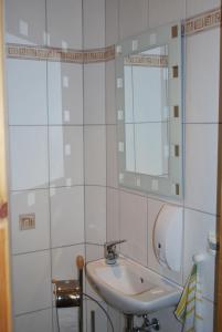 ein weißes Badezimmer mit einem Waschbecken und einem Spiegel in der Unterkunft Haus Grüne Idylle in Bannewitz