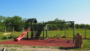 une aire de jeux avec un toboggan et une fille dessus dans l'établissement Tomaj Vendégház, à Tomajmonostora