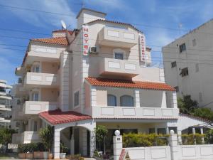 a large white building with a red roof at Parthenis Riviera Hotel in Athens