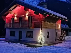 una casa con un albero di Natale davanti di B&B Lorelei a Gressoney-Saint-Jean