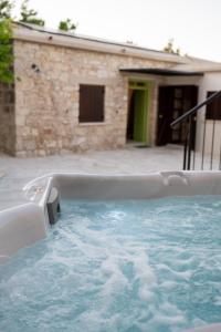 a hot tub in front of a house at Droshia Traditional Homes, COCO-MAT Full Experience in Droushia