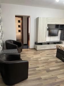 a living room with two chairs and a television at Apartament Untold in Turda