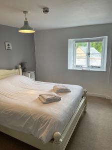 a bedroom with a bed with two towels on it at Red Lion Inn in Sidbury