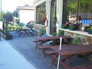 a group of picnic tables outside of a building at Hotel Edelweiss in Magland