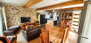 a living room with a leather couch and a tv at Le Micocoulier in Montesquieu