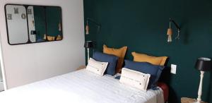 Un dormitorio con una cama con almohadas azules y amarillas. en Les Ruettes, en Saint-Germain-sur-Sarthe