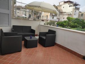 uma varanda com 2 cadeiras e um guarda-sol em La quiete del Vesuvio em Nápoles