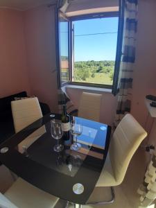 a dining room table with wine glasses and a window at Apartman Bukaleta in Loznati in Loznati +4 photos