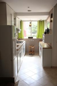 una cocina con electrodomésticos blancos y cortinas verdes en Appart Bin Elouidane en Bine el Ouidane